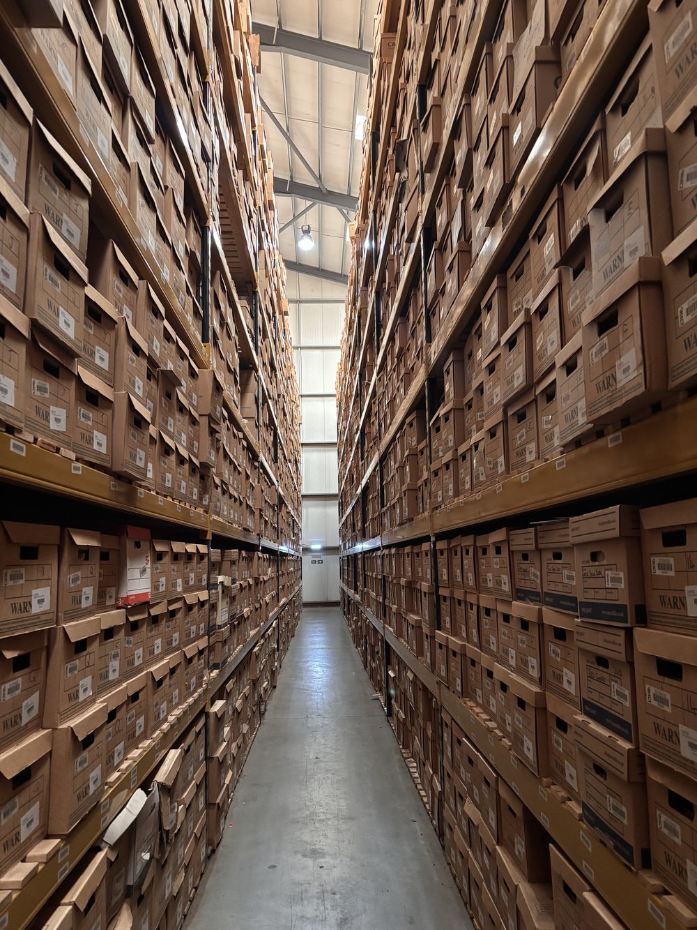 Sunlit aisle of barcoded archive boxes at Stor-a-File