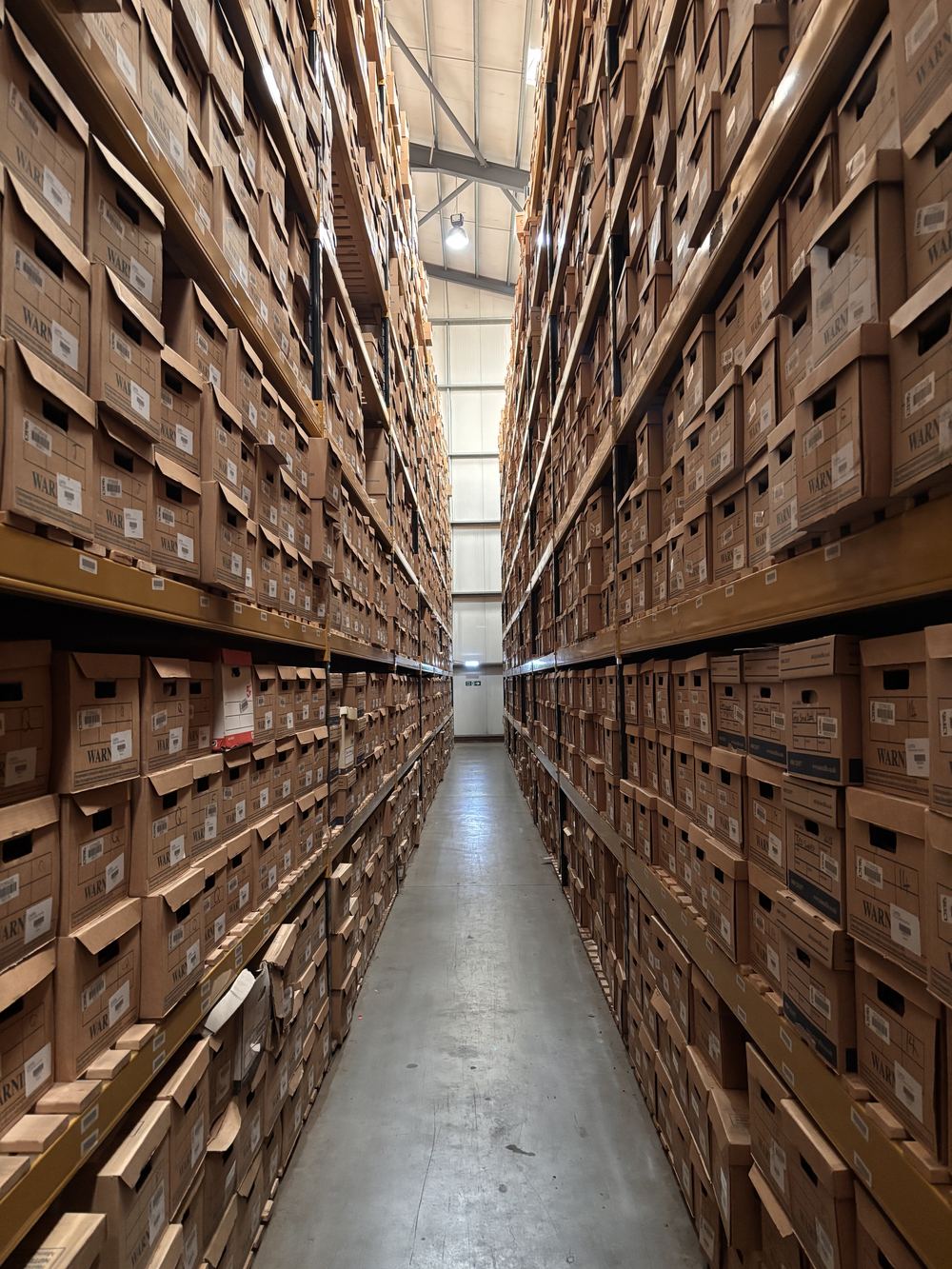 Sunlit aisle of indexed archive shelving at Stor-a-File