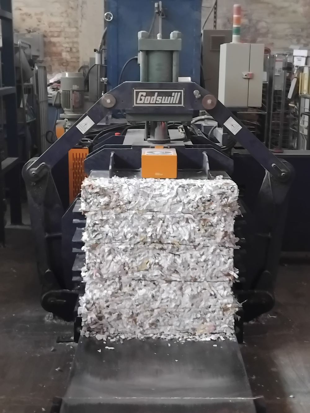 Bale of cross-cut shredded paper leaving the Stor-a-File baler