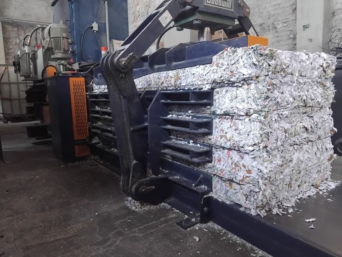 Industrial baler pressing bales of shredded paper at Stor-a-File